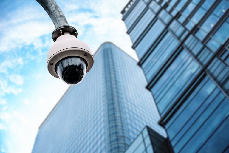 Security camera with a glass building on the background on the street