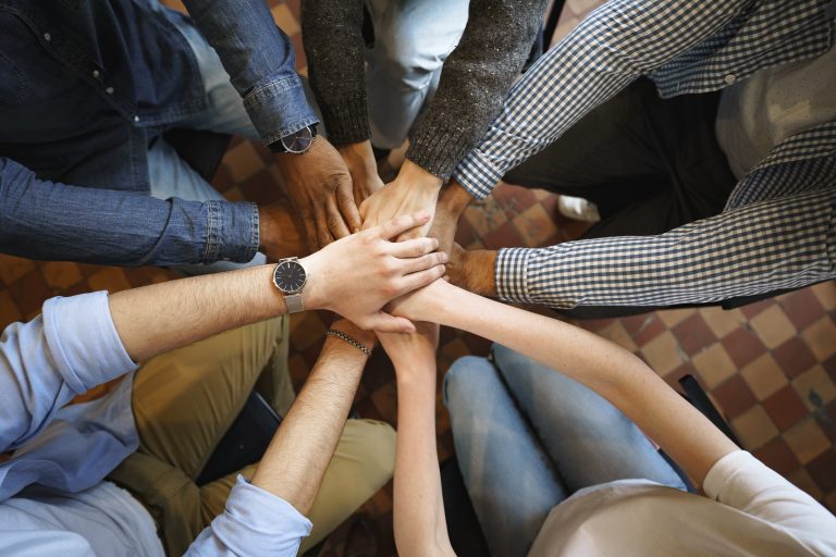 Top view of diverse people hands holding together in circle, hands stack, close up